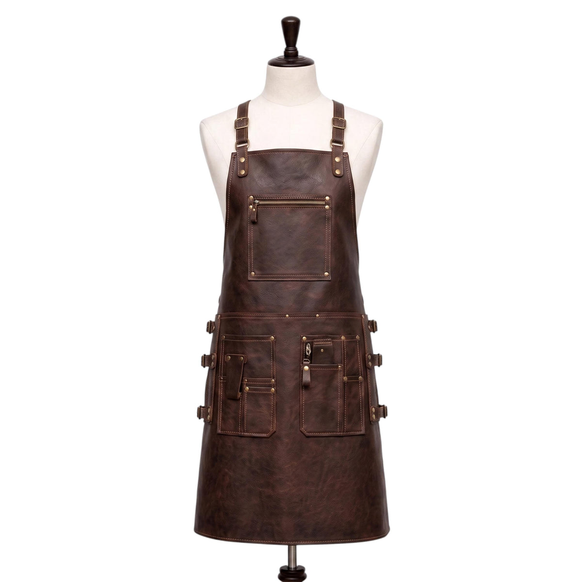"Front view of a full-length dark brown leather apron displayed on a fabric mannequin, featuring adjustable neck straps with brass buckles, a zippered chest pocket, and multiple front pockets on the waist section with buckle straps and brass rivets, photographed against a plain white background."