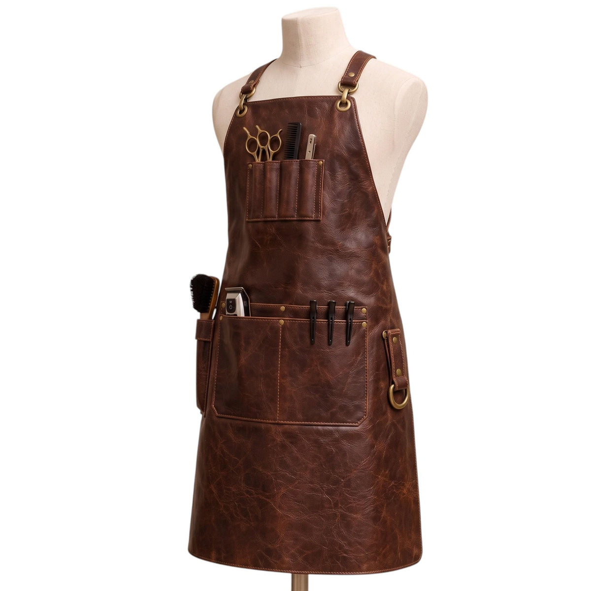 "Angled view of brown leather barber apron with tool pockets holding scissors, comb, clippers, pens, and brush, on a mannequin."