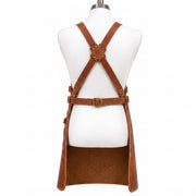 "Back view of brown leather work apron on mannequin, showing crossback straps with X-shaped brass-riveted leather patch, adjustable buckle waist strap, and side buckle straps, against a white background."