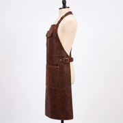 "Profile side view of brown leather apron showing chest pocket, waist buckle strap, and lower pocket on mannequin