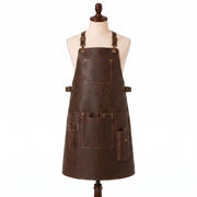 "Distressed brown leather apron with adjustable buckle straps, front chest pocket, waist pockets, and a scissor/tool loop, displayed on a mannequin against a white background."