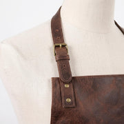 "Close-up of the leather apron's shoulder strap buckle and rivets."