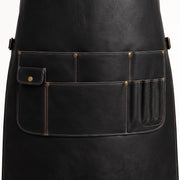 "Close-up of black leather apron's lower pocket section with flap pocket and narrow tool slots."