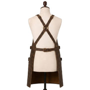 "Back view of distressed brown leather apron on a mannequin, showing crisscross X-back straps with brass buckles and an adjustable waist belt, against a white background."