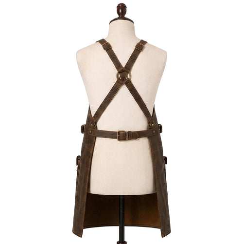 "Back view of distressed brown leather apron on a mannequin, showing crisscross X-back straps with brass buckles and an adjustable waist belt, against a white background."