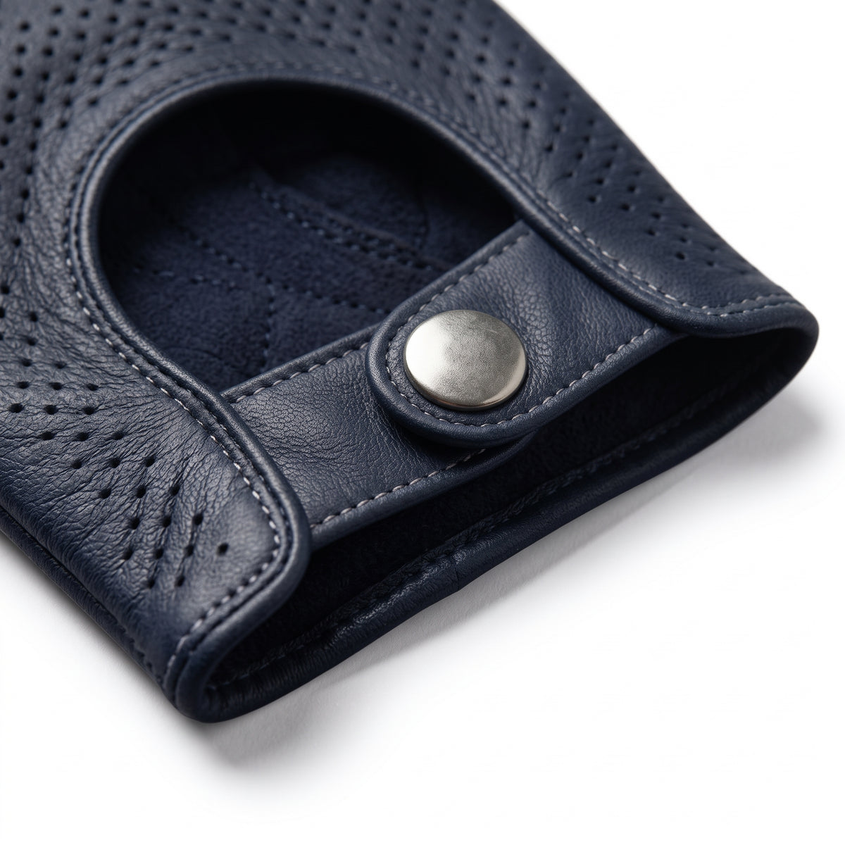 **"Close-up of navy leather glove's wrist snap button closure"**
