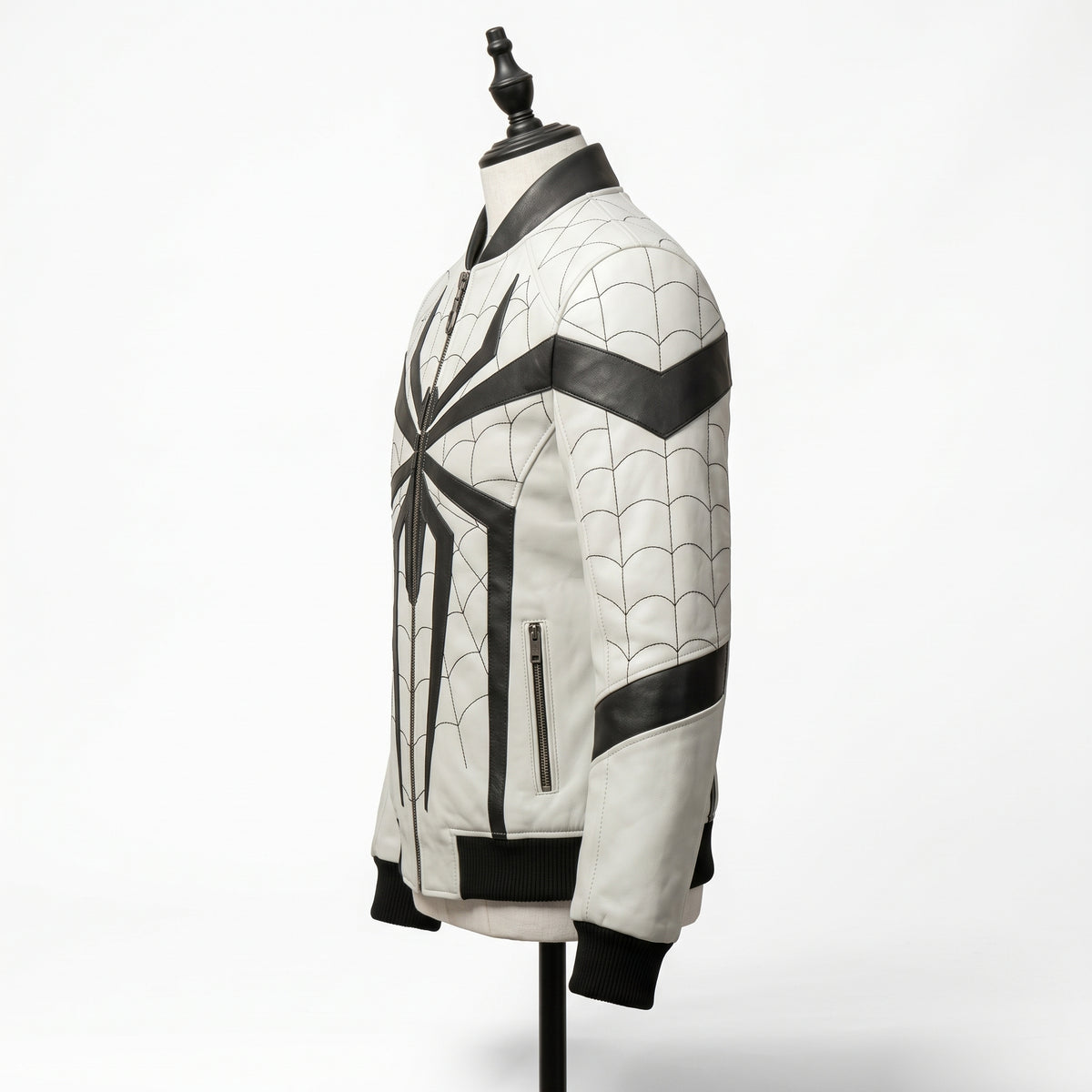 "Angled side view of a white leather bomber jacket with black spider graphic, web-pattern stitching, and black ribbed collar and cuffs, displayed on a mannequin against a white background."