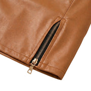 "Close-up detail of gold metal zipper on brown faux leather mini skirt hem, showing zipper pull, teeth, and stitched leather texture."