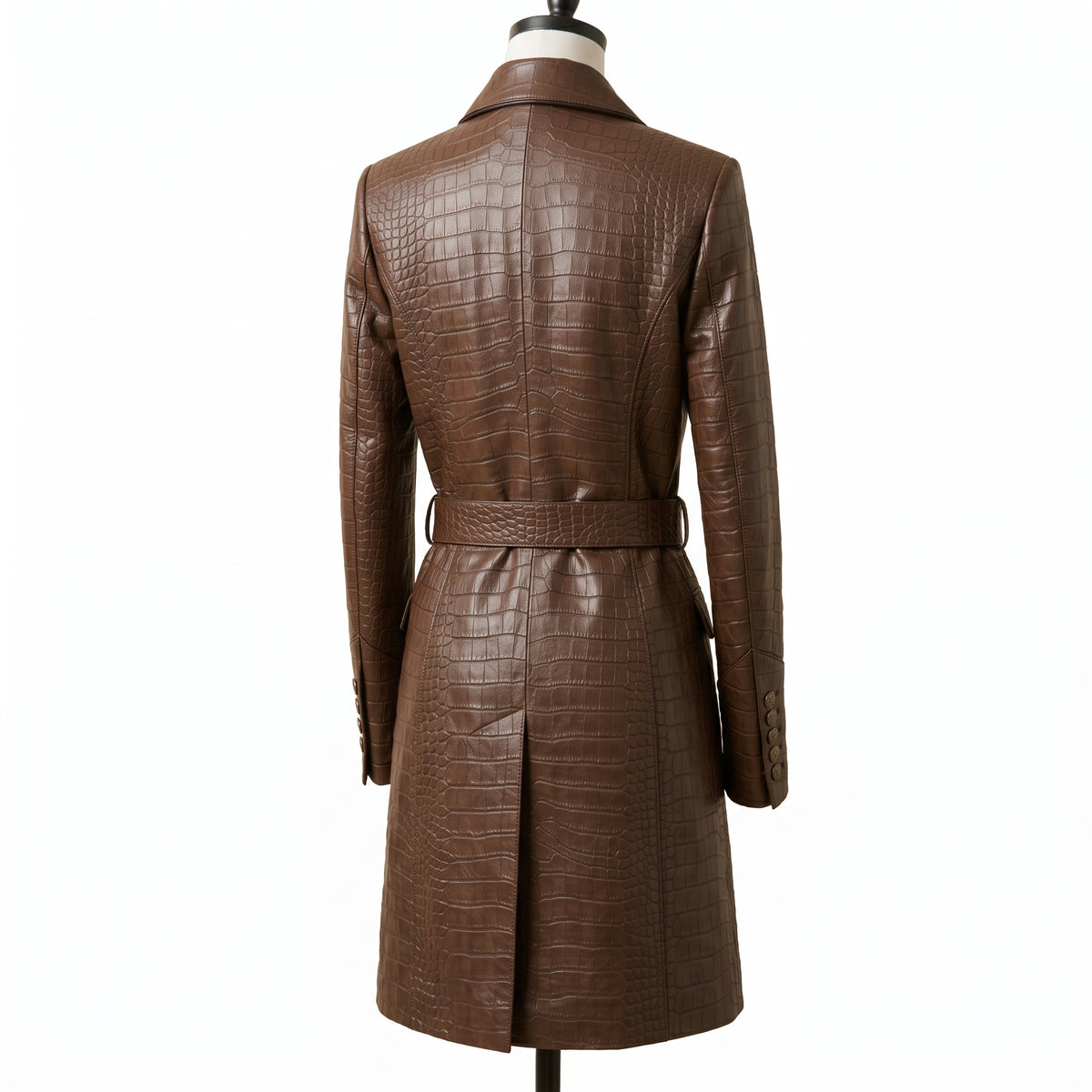 A brown crocodile-embossed leather trench coat displayed on a mannequin from the back view, featuring a matching belt at the waist.