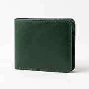 A dark green leather bifold wallet with visible stitching and a textured finish, shown standing upright on a clean white background.