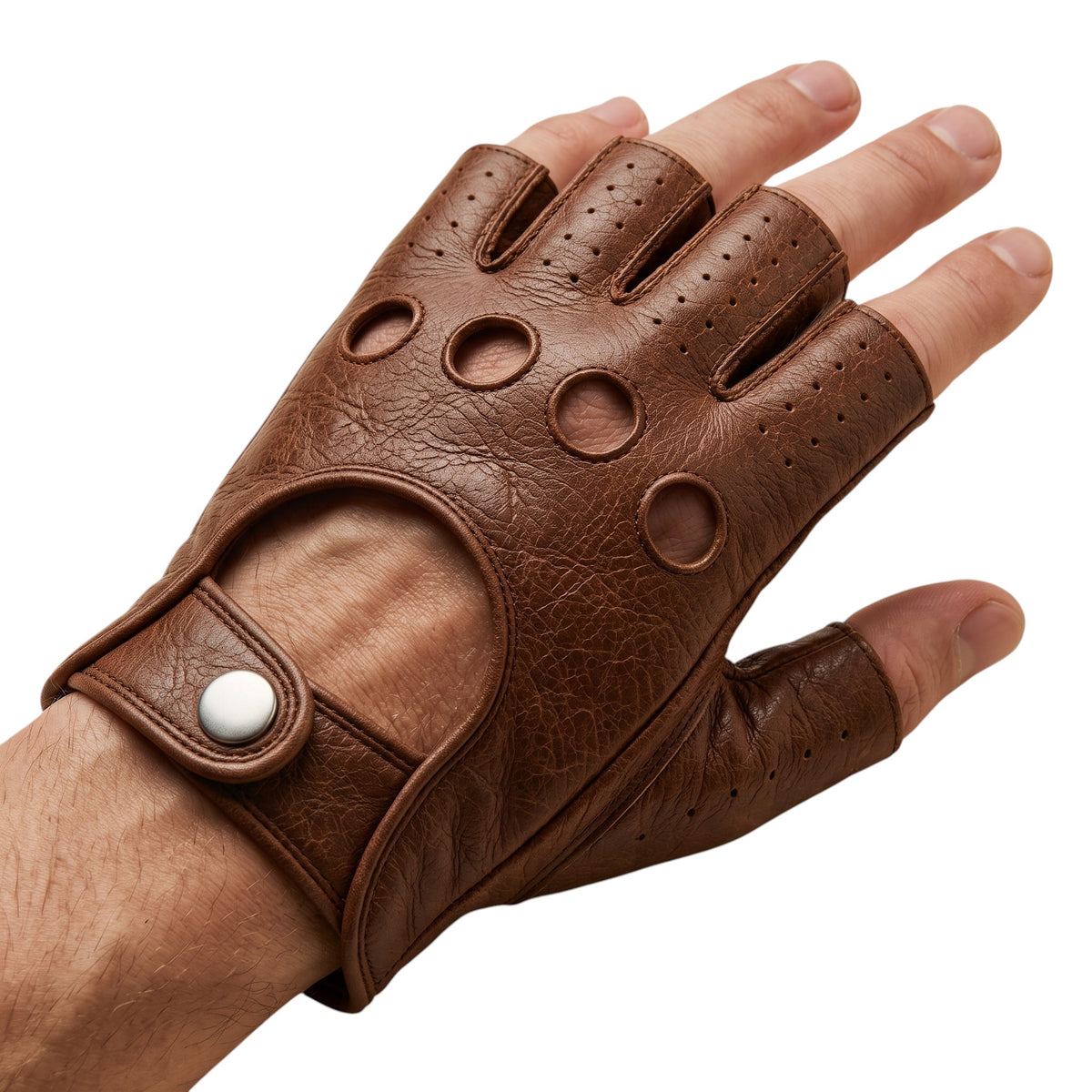 "A hand wearing a brown leather fingerless driving glove with open fingertips, circular ventilation holes on the knuckle area, and a snap-button wrist strap, photographed on a white background."