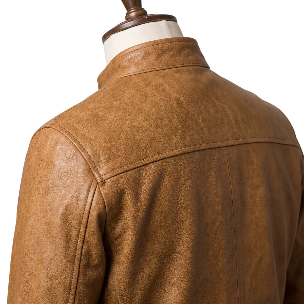 "Close-up of the back collar and shoulder area of a tan leather biker jacket, showing the yoke seam and natural leather grain texture in detail."