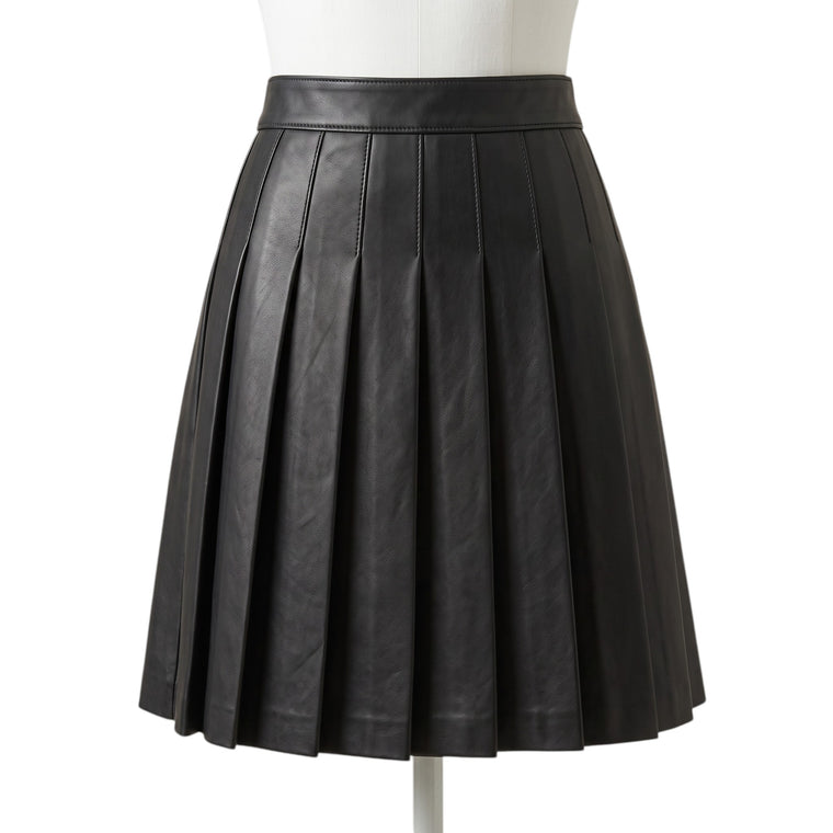 "A black leather pleated mini skirt on a mannequin, showing a smooth waistband and full box pleats creating an A-line silhouette against a white background."