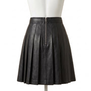 "Back view of the black leather pleated mini skirt on a mannequin, showing a center back zipper closure and full box pleats against a white background."