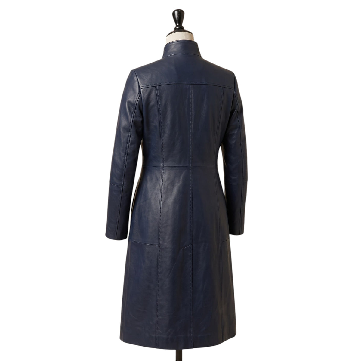 "Angled back view of a navy blue leather coat with a stand collar and fitted A-line silhouette, displayed on a mannequin against a white background."