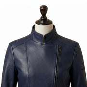 "Close-up of a navy blue leather coat's stand collar and asymmetric diagonal zipper detail, displayed on a mannequin against a white background."