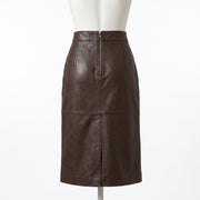 "Back view of the dark brown leather pencil skirt on a mannequin, showing a full-length center zipper closure and horizontal seam against a light background."