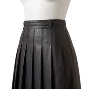 "Close-up of the waistband and box pleats on a black leather pleated skirt, showing a belt loop and detailed stitching."