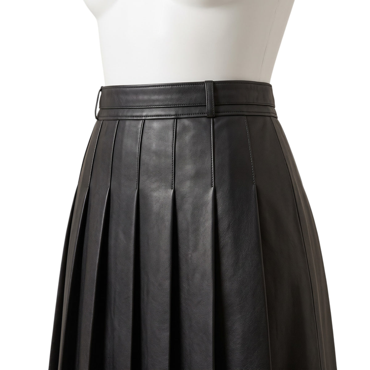 "Close-up of the waistband and box pleats on a black leather pleated skirt, showing a belt loop and detailed stitching."