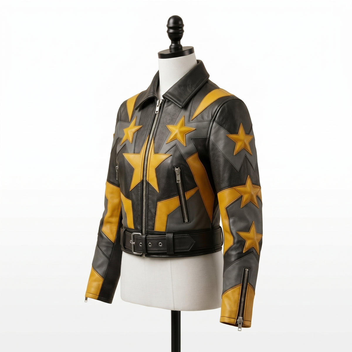 "Angled view of a black leather biker jacket with yellow and gray star graphic panels, asymmetric front zipper, zip pockets, and belted waist, displayed on a mannequin against a white background."