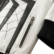 "Close-up detail of a white leather jacket pocket with spider-embossed zipper pull, black web-pattern stitching, and ribbed cuff."