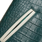 **"Close-up of green croc-embossed leather jacket's welt pocket detail"**
