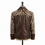 A brown leather jacket with zebra-print sleeves, displayed on a black mannequin torso against a plain white background.