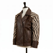 A brown leather and zebra-print jacket displayed on a mannequin torso against a plain white background.