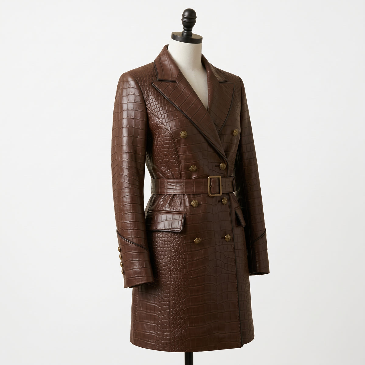 A brown crocodile-embossed double-breasted blazer with a matching belt and gold-tone buttons, displayed on a mannequin torso against a plain white background.