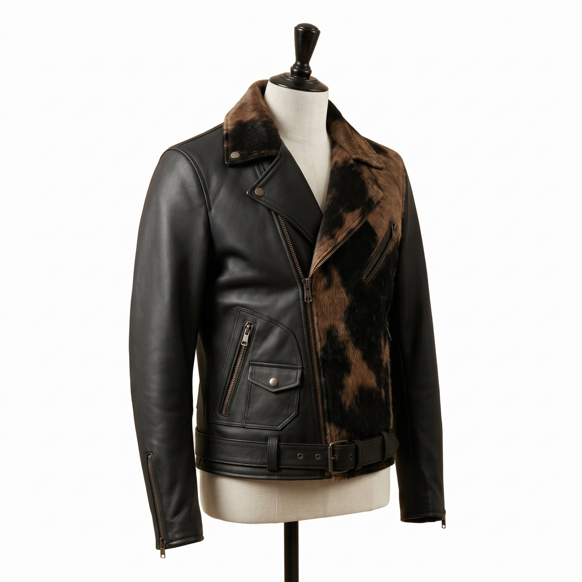 "Angled view of a black leather biker jacket with animal-print fur lapel panel, zip pockets, and belted waist, displayed on a mannequin against a white background."