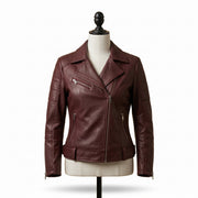 "Front view of a maroon leather biker jacket with asymmetric front zipper, notch lapel, multiple zip pockets, and stud detailing, displayed on a mannequin against a white background."