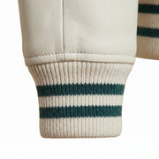 **"Close-up of white leather varsity jacket's ribbed striped cuff"**