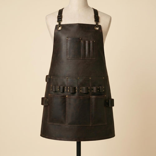 Front view of dark brown leather woodworking apron on mannequin with adjustable shoulder straps, chest pocket, tool loops and large utility pockets.