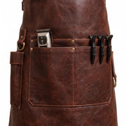 "Close-up of brown leather apron pocket holding a hair clipper and three black hair clips."