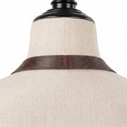 "Close-up of the leather apron's neck strap from the back."