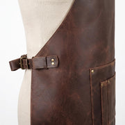 "Close-up of the leather apron's waist buckle and pocket edge."