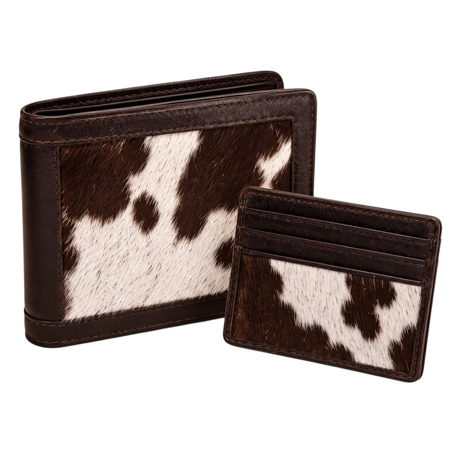 "Standing cow-print (brown and white) leather bifold wallet and matching card holder placed side by side, both with dark brown leather trim, photographed on a white background."