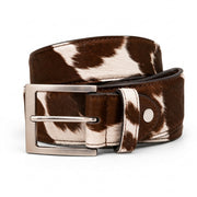 "Brown and white cow-print calf hair leather belt coiled to show buckle and loop detail, featuring a brushed silver-tone square buckle, photographed on a white background."