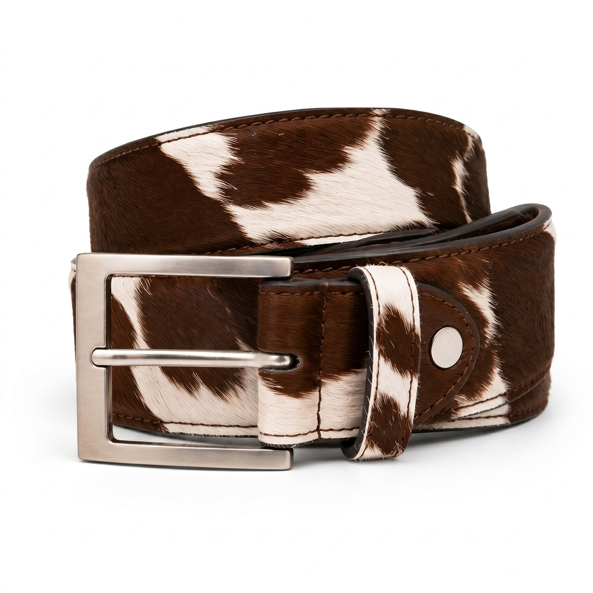 "Brown and white cow-print calf hair leather belt coiled to show buckle and loop detail, featuring a brushed silver-tone square buckle, photographed on a white background."