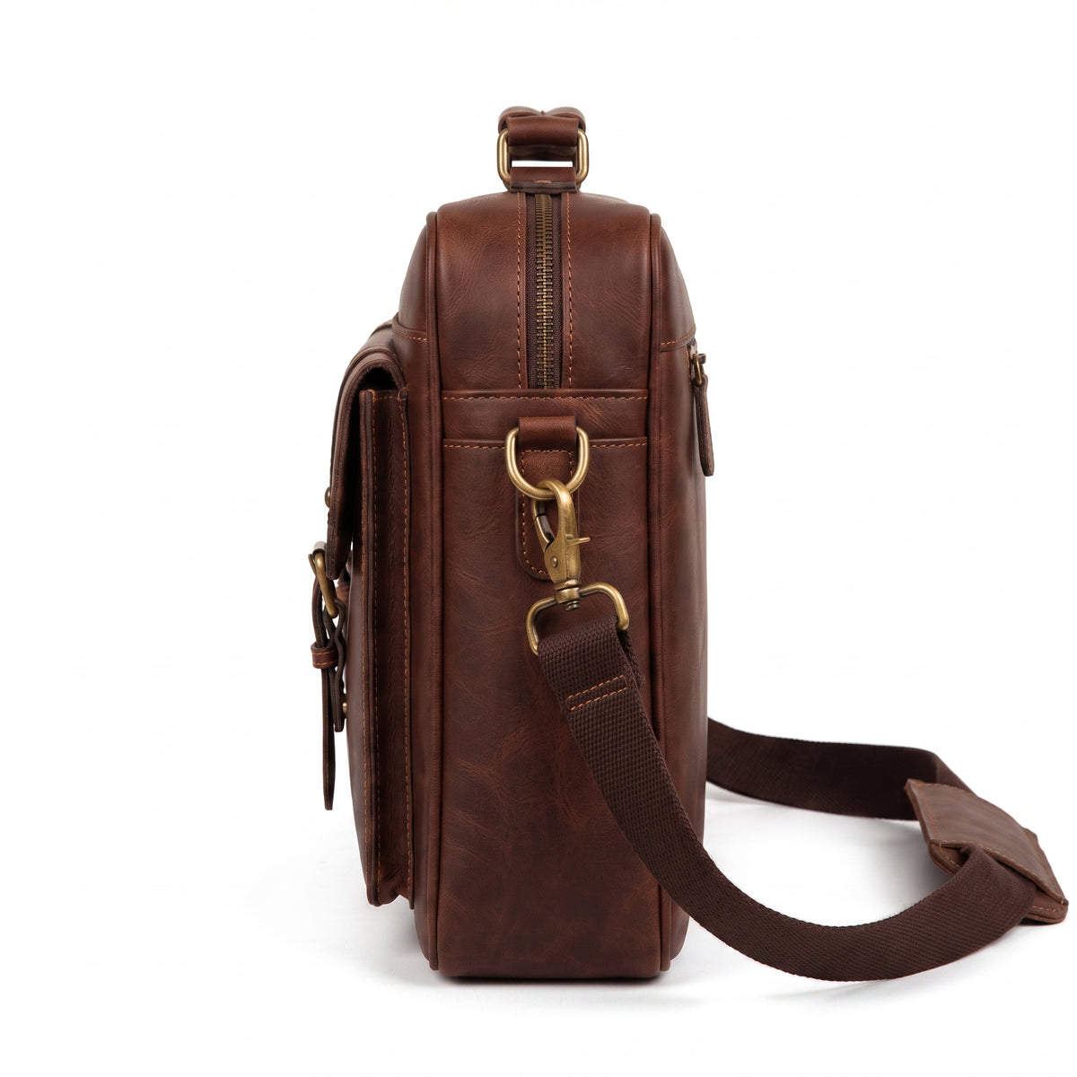 "Side view of the brown leather briefcase showing the curved zipper closure, a brass swivel clasp attaching the shoulder strap to a D-ring, and the strap hanging down against a white background