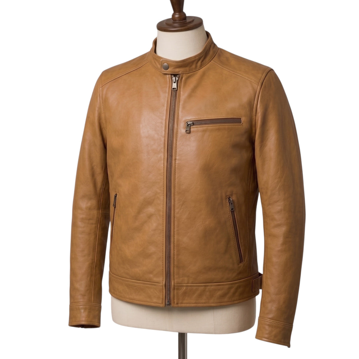 "Close-up of a tan leather biker jacket's collar and chest area on a mannequin, showing the snap button collar, front zipper, and chest zip pocket in detail."