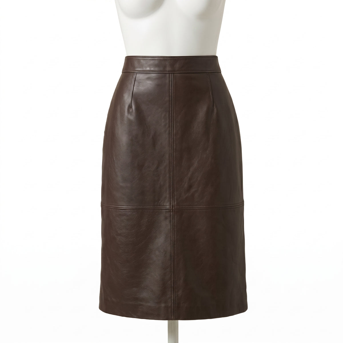 "A dark brown leather pencil skirt on a white mannequin, featuring a center seam and horizontal seam dividing it into four panels, with a knee-length hem against a white background."