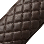"Extreme close-up of the diamond-quilted stitching pattern on a dark brown leather glove, shot at an angle showing the leather grain and padded texture."