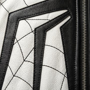 "Extreme close-up of white leather jacket texture with black web-pattern stitching, black leather panels, and zipper detail."